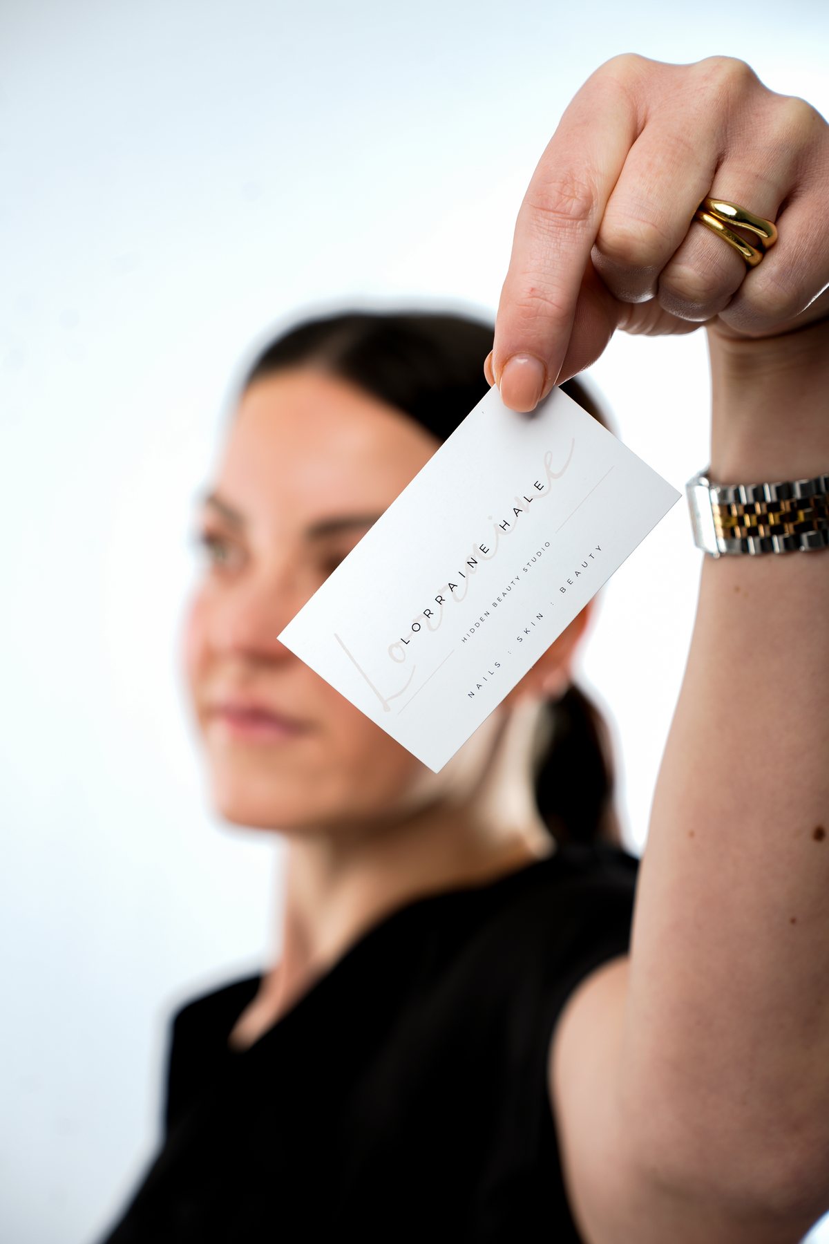 Lorraine holding up her business card, which reads Lorraine Hale, Hidden Beauty Studio, nails, skin and beauty