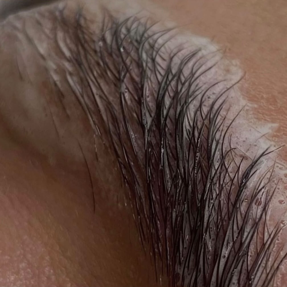 Brow lamination and tint being processed on the brow hairs